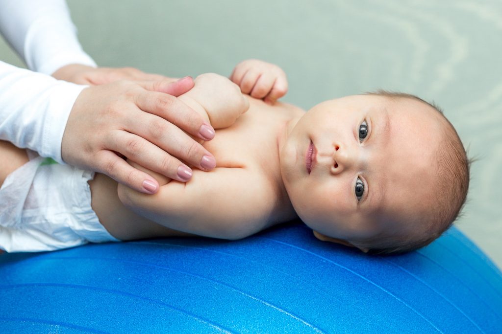 Novorodenec ležiaci na modrej fitlopte